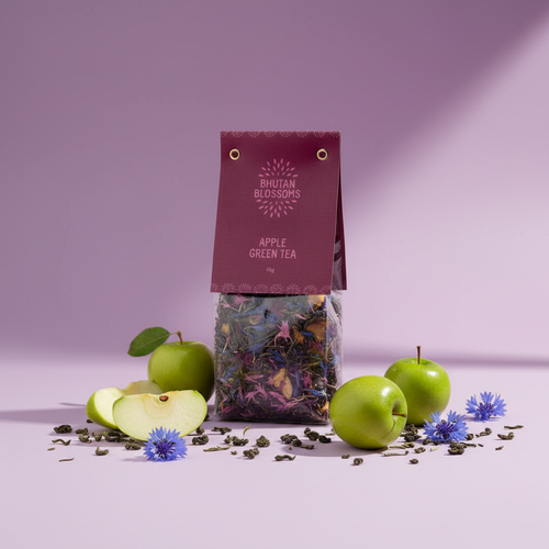 Bhutan Blossoms Apple Green Tea package with green apples and flowers on a purple background