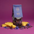 Bhutan Blossoms Pineapple Black Tea package with pineapple slices and flowers on a purple background